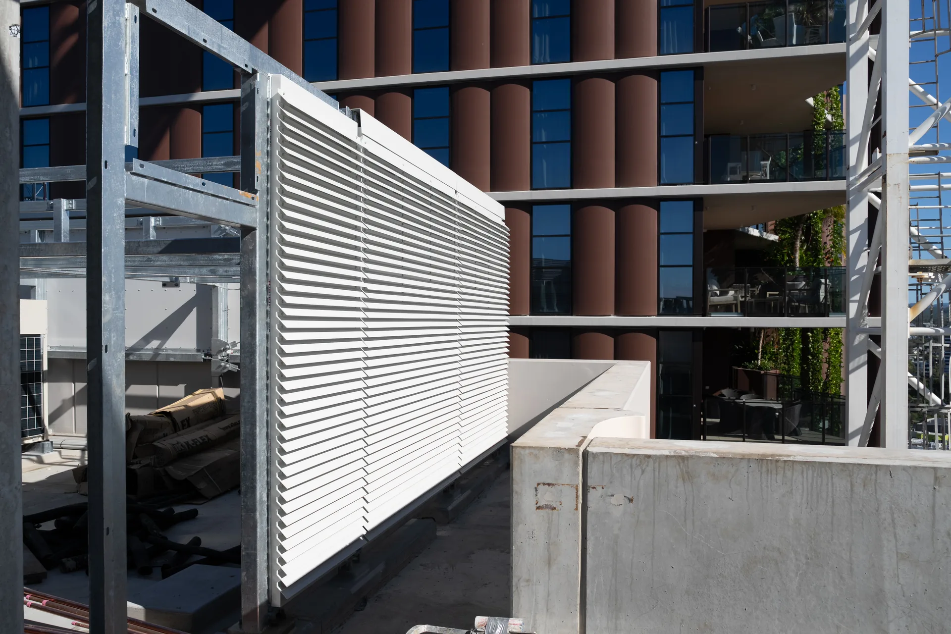 Structural aluminium sun-blade screening on a rooftop terrace, Allere West Village
