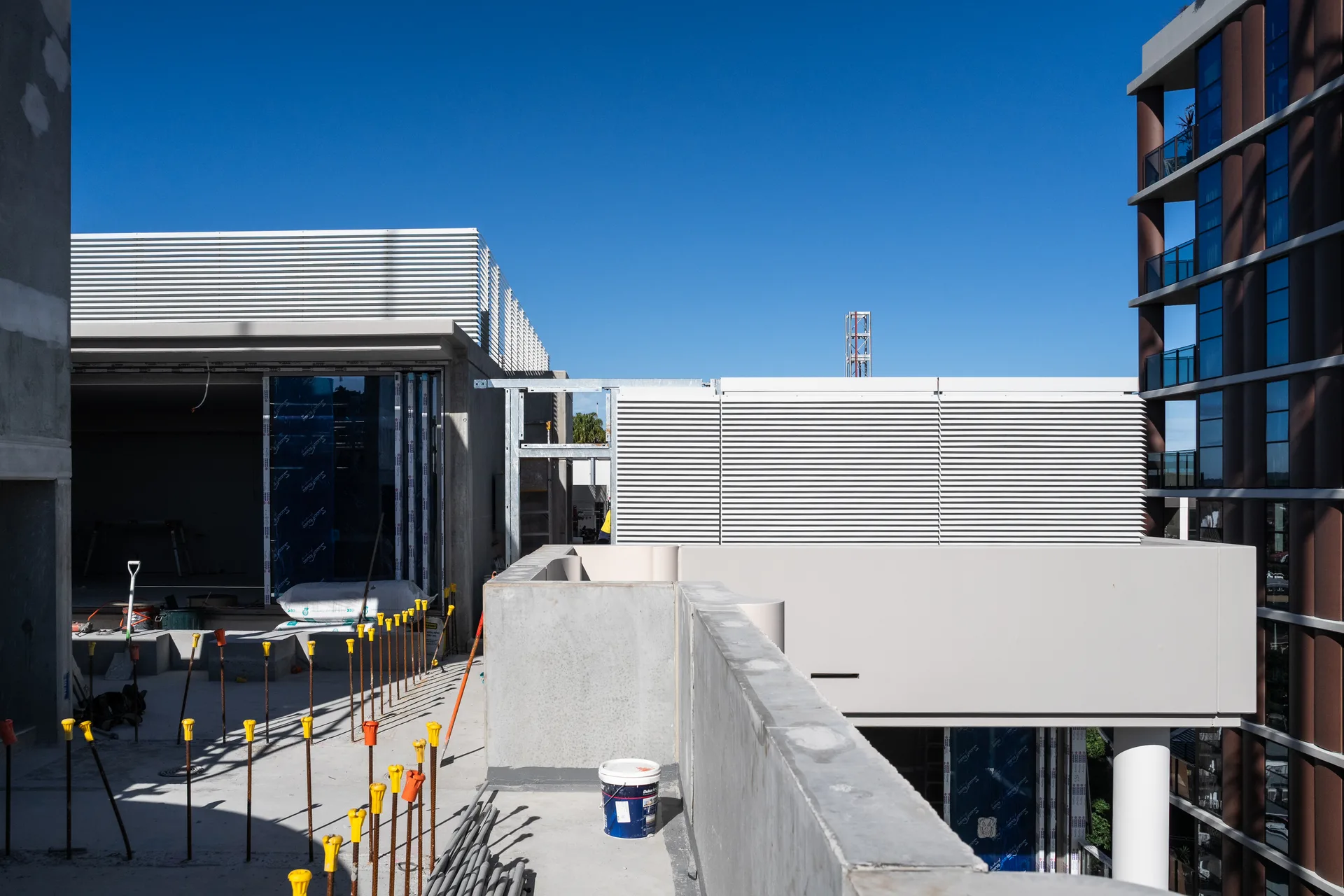 White aluminium louvre screens concealing rooftop plant, Allere West Village